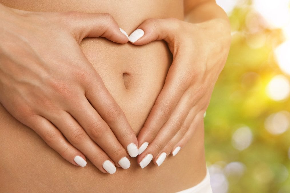 Woman with palms around bare belly button