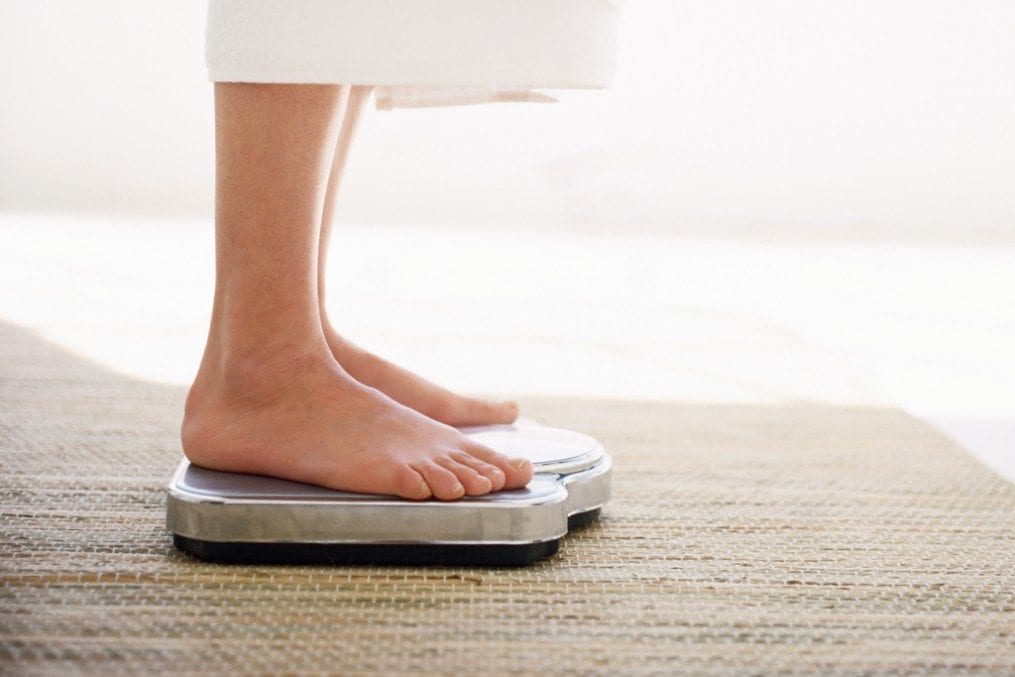 Woman checking weight on scale